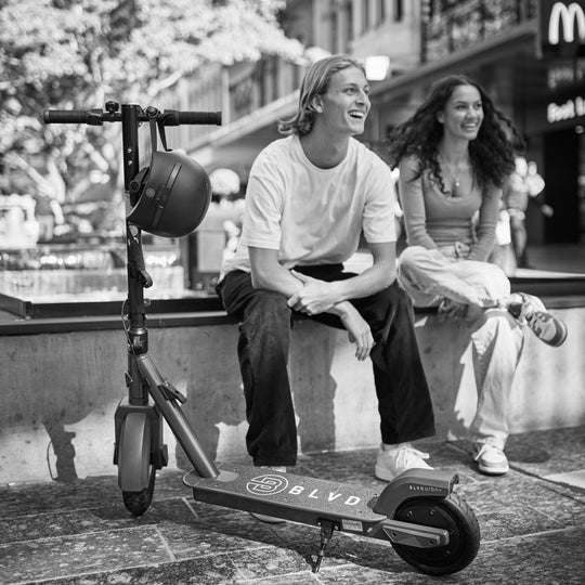 black and white image of a couple casually laughing with their blvd electric scooters